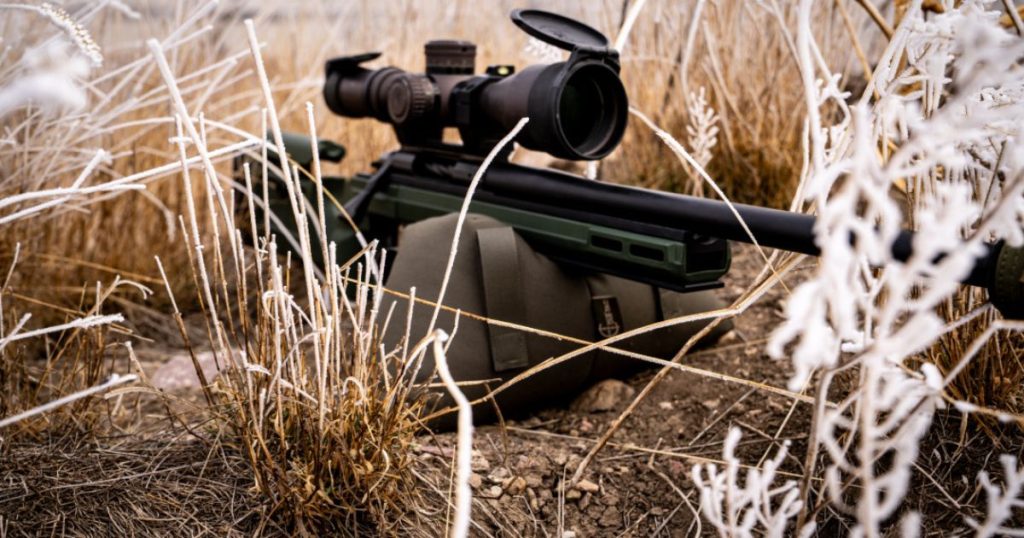 A hunting rifle resting on top of a Cole-TAC shooting support bag.