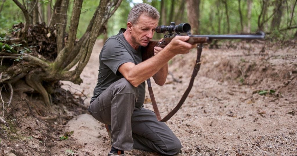 A man in the kneeling shooting position.