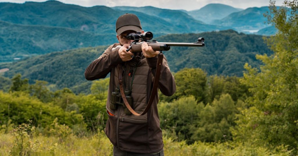 A hunter in a standing rifle shooting position.