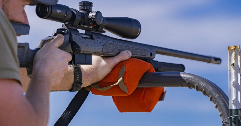 A rifle balanced on a Cole-TAC Revolution Shooting Bag filled.