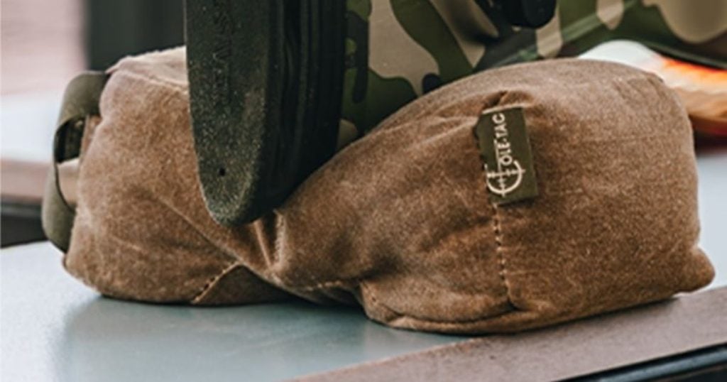 A rifle resting on a Cole-TAC shooting support bag.