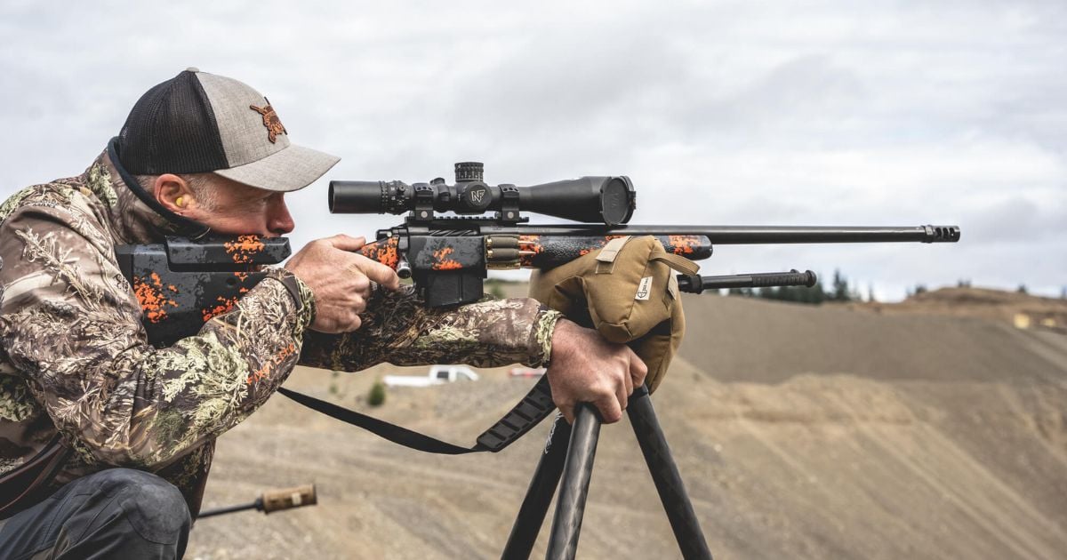 A man using a Cole-TAC shooting bag on his tripod getting ready to take his rifle shot.