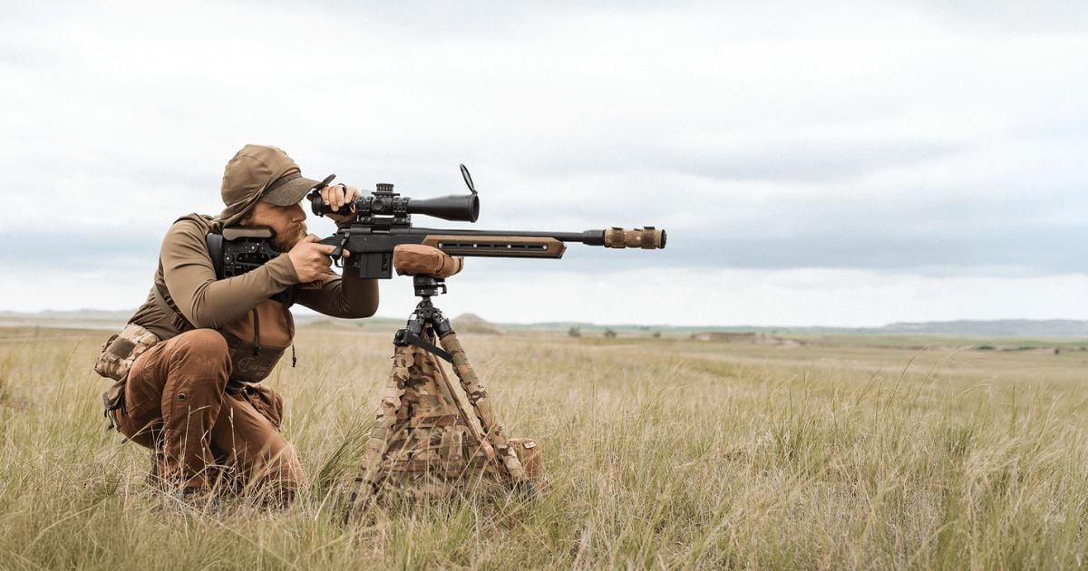 A man using a Cole-TAC shooting support bag to line up his rifle shot.